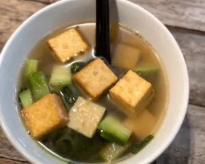 Table setting featuring the complete Tofu Day Recipes menu: tofu soup, spring rolls, and tomato tofu.