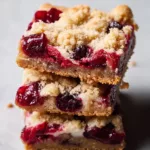 Homemade cranberry crumble bars with oat topping and fresh cranberries
