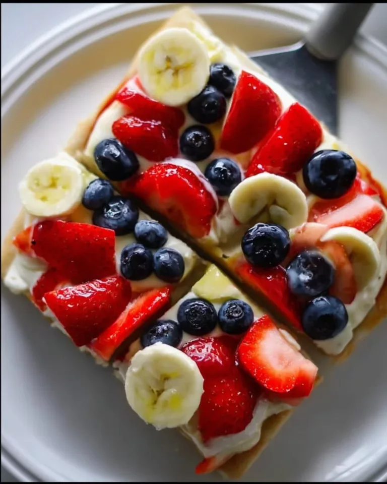 A colorful easy fruit pizza topped with fresh fruits and cream cheese frosting.