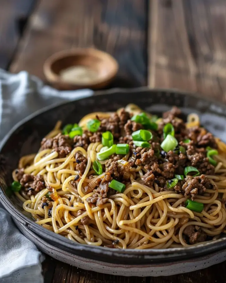 Delicious Mongolian ground beef noodles garnished with fresh vegetables