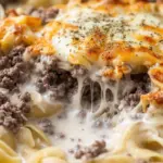 Creamy beef and shells in a bowl, garnished with herbs