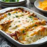 Creamy white chicken enchiladas topped with cheese and cilantro